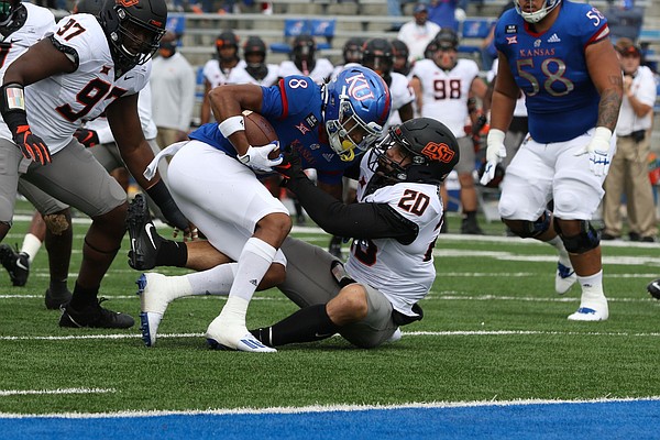 KU's Kwamie Lassiter Jr., is dragged down by an Oklahoma State defender during the Jayhawks' 47-7 loss to OSU on Saturday, Oct. 3, 2020 at David Booth Kansas Memorial Stadium. 