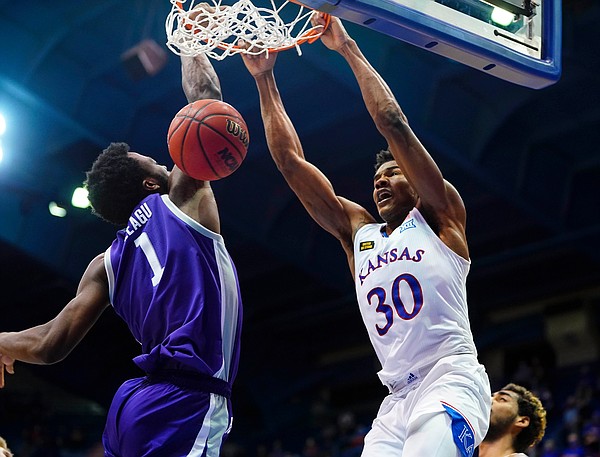 Kansas guard Ochai Agbaji (30) delivers a dunk against Kansas State forward Kaosi Ezeagu (1) during the second half on Tuesday, Feb. 2, 2021 at Allen Fieldhouse.