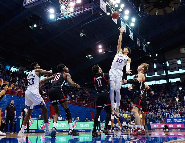 Kansas forward Jalen Wilson (10) shoots against Texas Tech guard Kyler Edwards (11) and guard Mac McClung (0) during the first half at Allen Fieldhouse Saturday afternoon in Allen Fieldhouse on Feb. 20, 2021. Photo by Jay Biggerstaff-USA TODAY Sports.