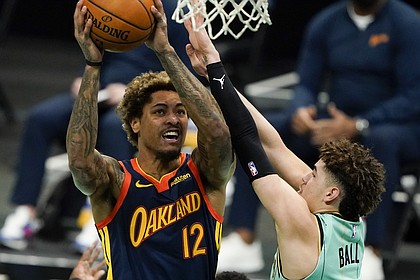 Golden State Warriors guard Kelly Oubre Jr. (12) shoots over Charlotte Hornets guard LaMelo Ball during the first half of an NBA basketball game on Saturday, Feb. 20, 2021, in Charlotte, N.C. (AP Photo/Chris Carlson)