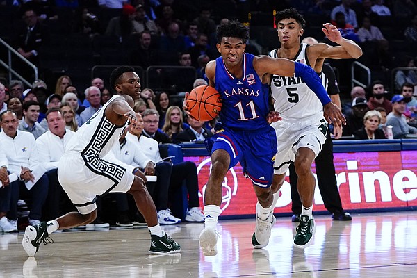 Kansas' Remy Martin (11) drives past Michigan State's Max Christie (5) and Tyson Walker during the second half of an NCAA college basketball game Tuesday, Nov. 9, 2021, in New York. (AP Photo/Frank Franklin II)