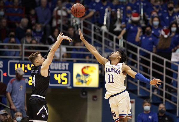 Kansas guard Remy Martin (11) defends against a three from Stephen F. Austin guard David Kachelries (4) during the second half on Saturday, Dec. 18, 2021 at Allen Fieldhouse.