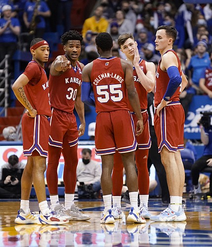 The Jayhawks come together in a huddle during at timeout in the second half on Saturday, Jan. 1, 2022 at Allen Fieldhouse.