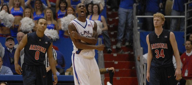 Kansas University's Darrell Arthur, center, lets out a scream as the Jayhawks pulled away from Arizona. At left is UA's Jerryd Bayless, while Chase Budinger is at right. Arthur led KU with 20 points in a 76-72 overtime victory Sunday at Allen Fieldhouse. Bayless and Budinger combined for 46 points.