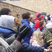 Kansas University defensive tackle Jamal Greene slaps hands with fans as he prepares to board a charter bus headed for Forbes Field. The Jayhawks received the royal treatment from fans on Thursday morning as they left Lawrence en route for Miami, where they will take on Virginia Tech in the Orange Bowl on Jan. 3.