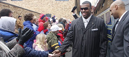 Kansas University defensive tackle Jamal Greene slaps hands with fans as he prepares to board a charter bus headed for Forbes Field. The Jayhawks received the royal treatment from fans on Thursday morning as they left Lawrence en route for Miami, where they will take on Virginia Tech in the Orange Bowl on Jan. 3.