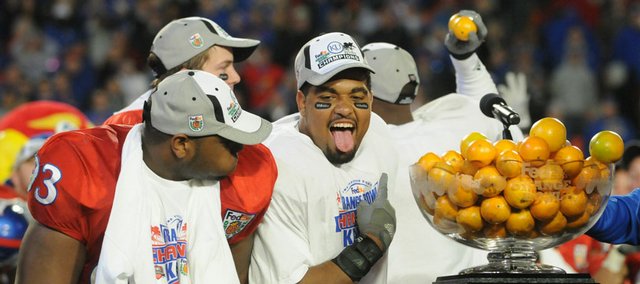 Kansas University running back Brandon McAnderson hams it up for the cameras with defensive end James McClinton after KU's 24-21 victory Thursday at the Orange Bowl in Miami.