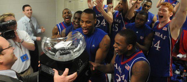 The Kansas University's men's basketball team receives the Big 12 Conference championship trophy from league commissioner Dan Beebe, left. KU's 72-55 victory over Texas A&M on Saturday in College Station, Texas, gave the Jayhawks at least a share of their fourth league crown in four seasons.