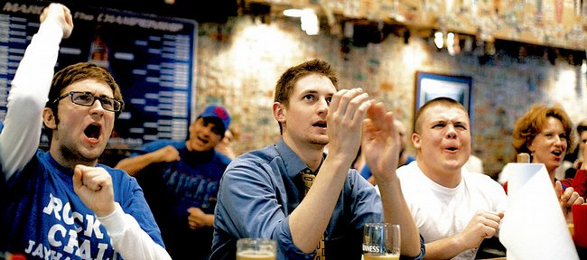 From left, KU seniors Corey O'Neal, of Leawood, Kyle Klem, of Denver, and David Ehret, of Topeka, cheer for the Kansas University Jayhawks on Saturday at Jefferson's Restaurant, 743 Mass. Klem said he filled out a bracket, but it isn't faring well. "Now I'm rooting for upsets in KU's bracket so we play easy teams," he said. 