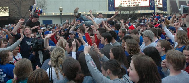 Hundreds of Kansas University fans filled Massachusetts Street on Sunday, with one even enjoying a little body-surfing, after KU advanced to its first Final Four since 2003 in the NCAA basketball tournament. The Jayhawks defeated Davidson 59-57 Sunday in thrilling fashion and will face North Carolina and former KU coach Roy Williams on Saturday in San Antonio. 