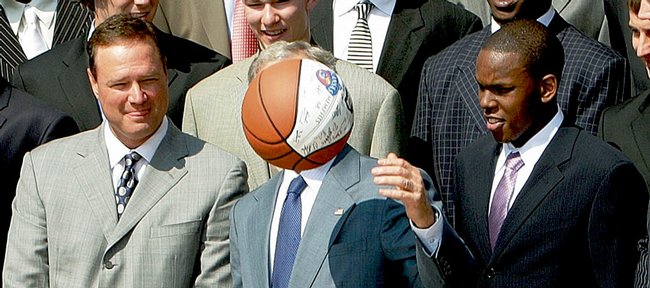 Kansas basketball Coach Bill Self, left, and guard Russell Robinson, right, watch as President Bush, center, bounces the basketball given to him as he honored the 2008 NCAA men's national basketball championship team from the University of Kansas, Tuesday, June 3, 3008, in the Rose Garden of the White House in Washington.