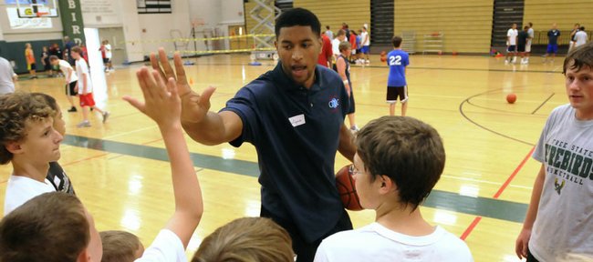 Wayne Simien high-fives his campers after running through the importance of working hard off the ball on defense. Simien ran the first session of his "Called to Greatness" basketball camp on Tuesday at Free State High.