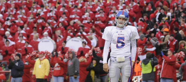 With a sea of red-clad Nebraska fans as backdrop, Kansas University quarterback Todd Reesing leaves the field after throwing a fourth-quarter interception. Though Reesing threw for 304 yards, the Jayhawks suffered a 45-35 loss to the Huskers on Saturday in Lincoln, Neb.