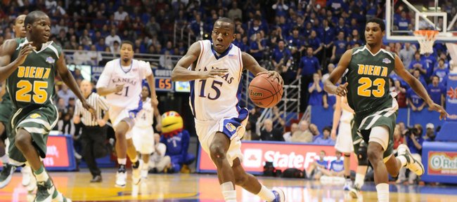 Kansas guard Tyshawn Taylor races down the court between Siena defenders Ronald Moore, left, and Edwin Ubiles during the second half Tuesday at Allen Fieldhouse.