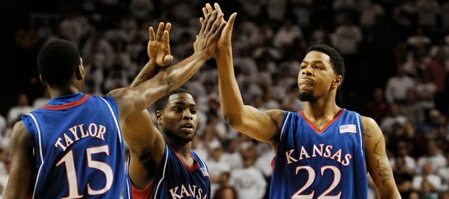 Kansas players Tyshawn Taylor, Sherron Collins and Marcus Morris come together for a collective high five after a bucket in the first half at the Lloyd Noble Center in Norman, Okla.