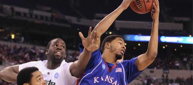 Kansas forward Markieff Morris rips a rebound away from Michigan State defenders Chris Allen, front, and Draymond Green during the first half Friday, March 27, 2009 at Lucas Oil Stadium in Indianapolis.