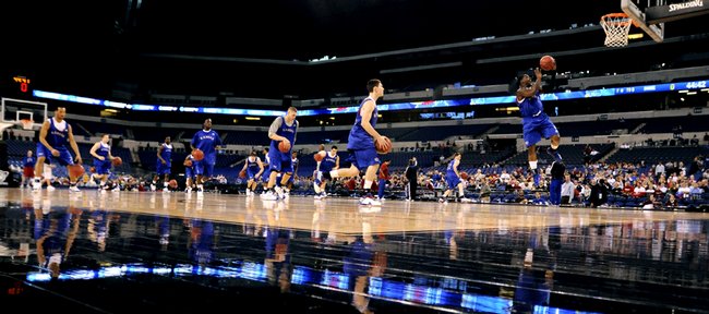 A procession of Jayhawks charge up the court during their first practice Thursday at Lucas Oil Stadium in Indianapolis.