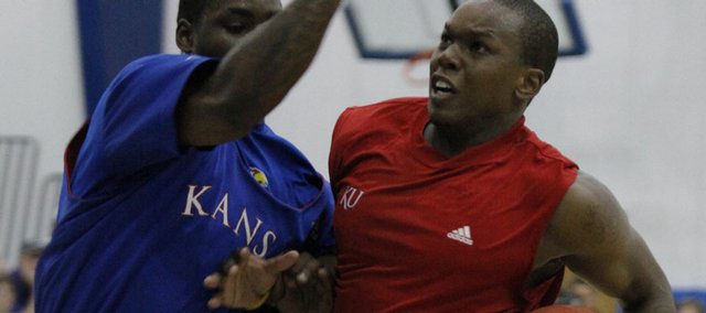 Kansas guard Sherron Collins tries to block the path of former KU player Russell Robinson. Current and former Jayhawk players scrimmaged Wednesday at Horejsi Center during the Bill Self camp. 