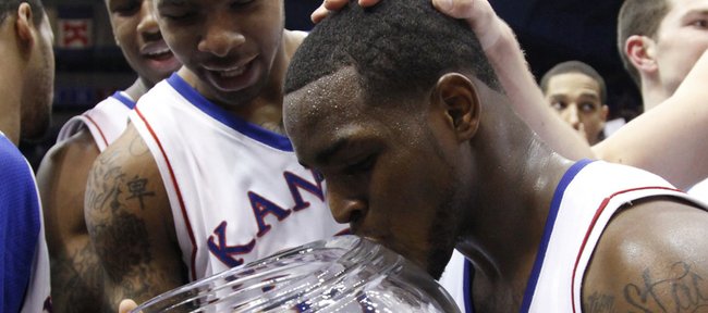 Kansas guard Sherron Collins kisses the Big 12 championship trophy after the Jayhawks' win over Oklahoma, Monday, Feb. 22, 2010 at Allen Fieldhouse. In back is Kansas forward Marcus Morris.