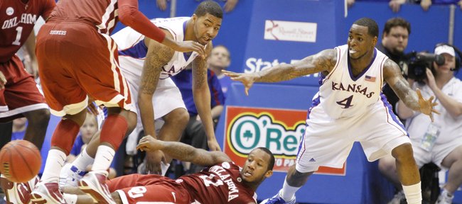 Kansas players Markieff Morris, left, and Sherron Collins defend as Oklahoma guard Tommy Mason-Griffin throws a pass from the floor during the second half, Monday, Feb. 22, 2010 at Allen Fieldhouse.