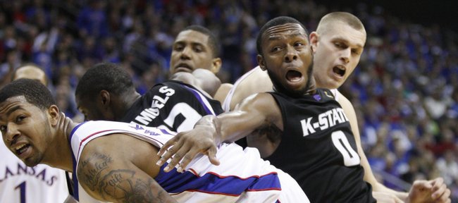 Kansas forward Markieff Morris, left, and center Cole Aldrich get physical with Kansas State guard Jacob Pullen going for a rebound during the second half Saturday in Kansas City, Mo.