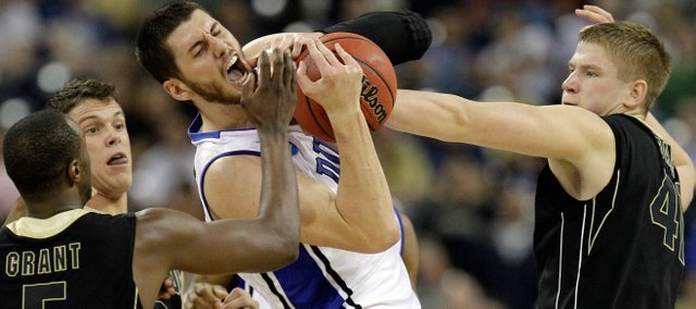 Duke's Brian Zoubek battles for a rebound against Purdue's Keaton Grant (5), Chris Kramer and Patrick Bade, right, during the first half of an NCAA South Regional semifinal college basketball game in Houston, Friday, March 26, 2010.