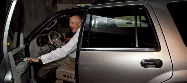 Kansas University athletic director Lew Perkins smiles as he is approached by media members Thursday in the parking garage adjacent to Allen Fieldhouse. On Thursday, Perkins announced his intention to resign from his position after the 2010-11 academic year but did not comment.