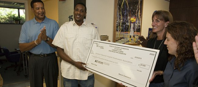 Former Kansas University basketball star Mario Chalmers presents a $25,000 check on Thursday, June 24, 2010, to employees of Lawrence Memorial Hospital Regional Oncology Center. The donation will establish the first "Mario's Closet," a specialty shop for a variety of free or low cost accessories for cancer patients. Pictured from left are Mario's dad, Ronnie Chalmers, Mario Chalmers, Sheryle D'Amico, director of oncology services, and Dr. Sharon Soule, an oncologist.
