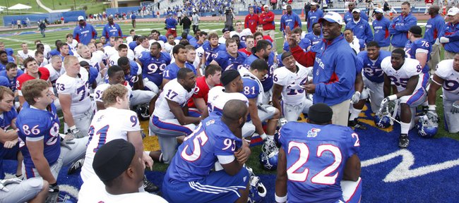 Kansas University football coach Turner Gill, right, addresses his team following the spring game on April 24 at Memorial Stadium. Gill has implemented a cell-phone policy on the team, as cell phones are collected on the day before a game and returned to the players after the game to limit distractions.