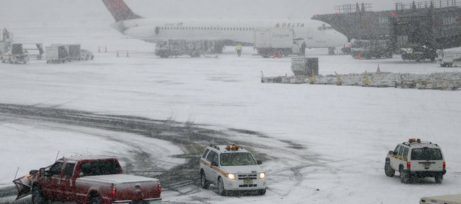 A Delta plane is seen at Newark Liberty International Airport during a snow storm Dec. 26, 2010, in Newark, N.J. Airlines are working to rebook stranded passengers and possibly add flights after a winter storm on the East Coast caused thousands of flight cancellations and left countless passengers stranded. Kansas University's Tyshawn Taylor was among the Jersey travelers snowbound Sunday.