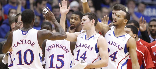 Kansas players Tyrel Reed (14) and Travis Releford (far right) congratulate Tyshawn Taylor during a timeout in the first half against UMKC on Wednesday, Jan. 5, 2011 at Allen Fieldhouse.