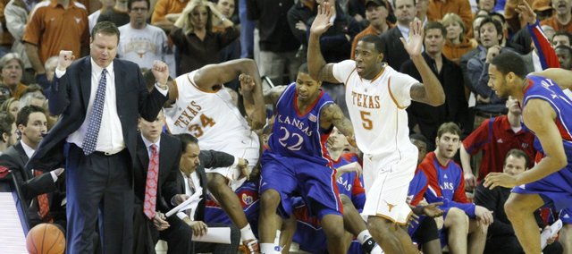 Kansas head coach Bill Self steers clear as Texas center Dexter Pittman (34) and Kansas forward Marcus Morris (22) crash into the Jayhawks bench going for a loose ball in the first half, Monday, Feb. 8, 2010 at the Frank Erwin Center in Austin.