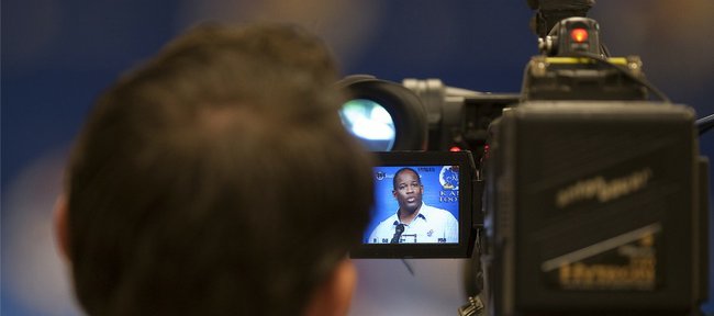 Kansas University football coach Turner Gill is seen in a camera man’s monitor during a news conference. Gill was announcing his recruiting class of 2011 on Wednesday, Feb. 2, 2011 at Mrkonic Auditorium.