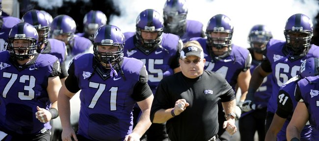 In this photo taken Saturday, Oct. 1, 2011, TCU head coach Gary Patterson runs onto the field with his team before a game against SMU in Fort Worth, Texas.