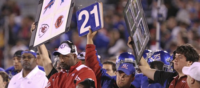 Image boards featuring NFL icons are held up from the Kansas bench during Saturday's home game against Oklahoma as what was later explained to be an attempt to simplify the play calling.