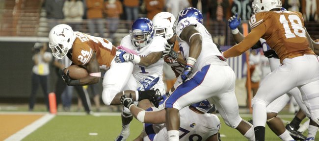 Kansas safety Lubbock Smith (1) and the Jayhawk defense can't hold back Texas running back Joe Bergeron as he marches through for a touchdown during the third quarter on Saturday, Oct. 29, 2011 at Darrell K Royal-Texas Memorial Stadium.