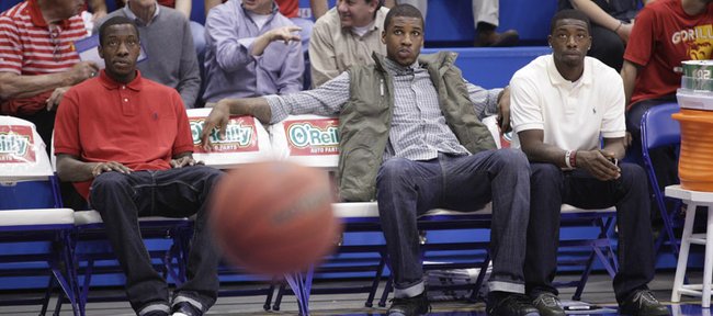 Kansas projected starters Tyshawn Taylor, left, Thomas Robinson and Elijah Johnson watch warm-ups prior to KU's game against Pittsburg State on Tuesday, Nov. 1, 2011 at Allen Fieldhouse. Taylor and Johnson were suspended; Robinson is nursing an injury.