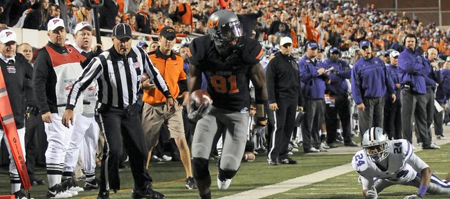 Kansas state defensive back Nigel Malone (24) looks on as Oklahoma State wide receiver Justin Blackmon (81) runs for a touchdown during the first quarter of Saturday's game in Stillwater, Okla. Oklahoma State defeated Kansas State, 52-45.