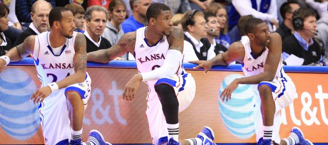 Kansas teammates Travis Releford, left, Thomas Robinson and Justin Wesley strike a similar pose as the three wait to check into the game against Fort Hays State during the first half on Tuesday, Nov. 8, 2011 at Allen Fieldhouse.