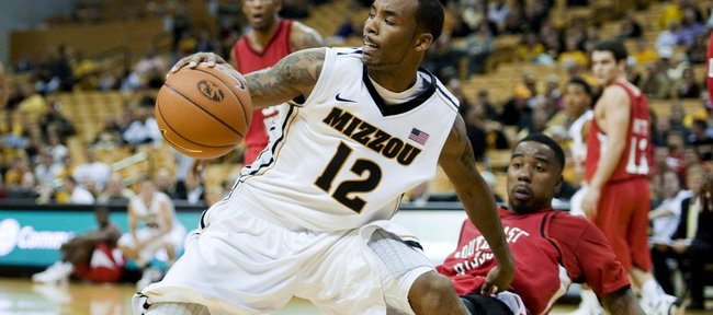 Missouri's Marcus Denmon, left, holds on to the ball as Southeast Missouri State's Marland Smith, right, falls back as he defends during the second half Friday, Nov. 11, 2011, in Columbia. Mo. Missouri won the game, 83-68.