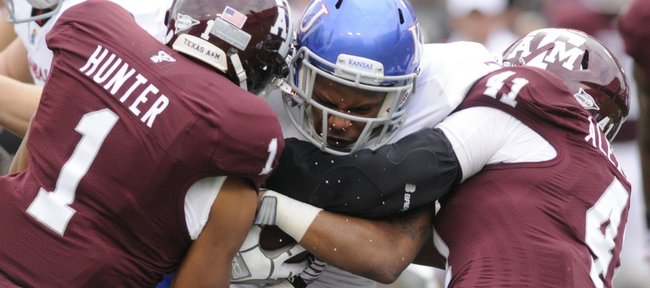 Kansas running back Darrian Miller is squeezed by the A&M defense in the first half Saturday, Nov. 19, 2011 at Kyle Stadium in College Station, Texas.