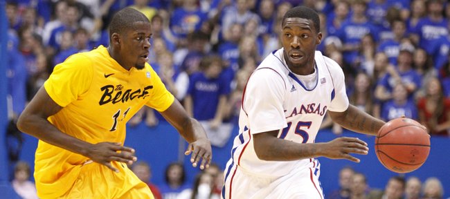 Kansas guard Elijah Johnson looks to push the ball up the court as he is defended by Long Beach State forward James Ennis during the first half on Tuesday, Dec. 6, 2011 at Allen Fieldhouse.