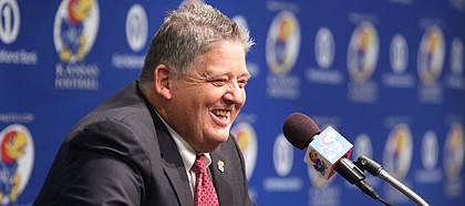 Charlie Weis laughs at the podium as he addresses media members during a news conference in which Weis was announced as the new football coach for KU on Friday, Dec. 9, 2011 at the Anderson Family Football Complex.