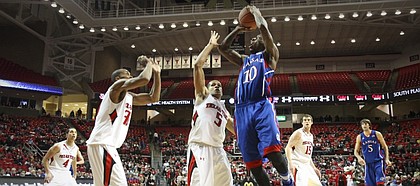 Kansas guard Tyshawn Taylor pulls up for a shot over Texas Tech defenders Javarez Willis (5) and Jaye Crockett during the first half Wednesday, Jan. 11, 2012, at United Spirit Arena.