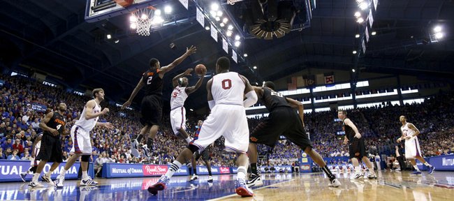Kansas guard Elijah Johnson swoops into the lane under Oklahoma State forward Le'Bryan Nash as the Jayhawks work against a zone defense during the second half on Saturday, Feb. 11, 2012 at Allen Fieldhouse.