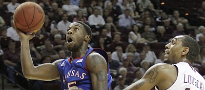 Kansas guard Elijah Johnson drives by Texas A&M forward David Loubeau after stealing the ball during the first half of the Jayhawks' game against the Aggies on Wednesday, Feb. 22, 2012, in College Station, TX.