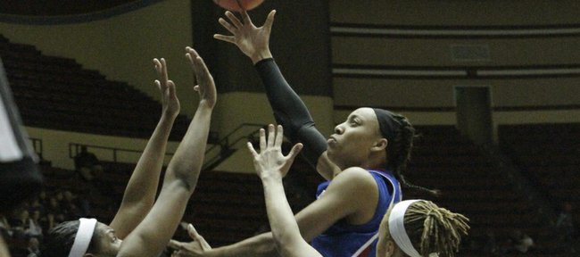 Kansas' Aishah Sutherland skies over a pair of A&M defenders during their Big 12 tournament game on Thursday, March 8, 2012, at Municipal Auditorium in Kansas City, Mo.