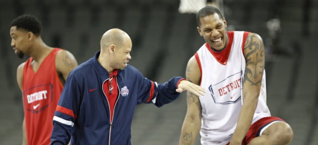 Detroit head coach Ray McCallum reaches out to slap hands with center Eli Holman as the Titans start their practice at Century Link Center in Omaha.