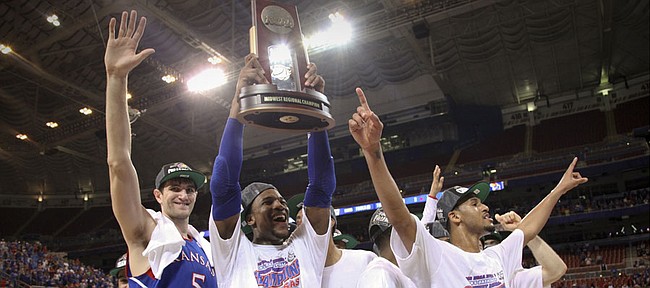 Kansas forward Thomas Robinson hoists the Midwest Regional trophy as he and teammates Jeff Withey and Travis Releford celebrate the Jayhawks' 80-67 win over North Carolina to advance to the Final Four on Sunday,  March 25, 2012 at the Edward Jones Dome in St. Louis.