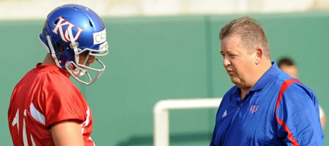 Kansas University quarterback Dayne Crist, left, listens to KU coach Charlie Weis during spring drills on Tuesday, March 27, 2012, at the practice fields south of Memorial Stadium.